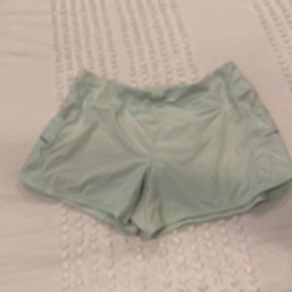 Athleta Ladies running shorts with reflective trim, zipped key pocket. size M
